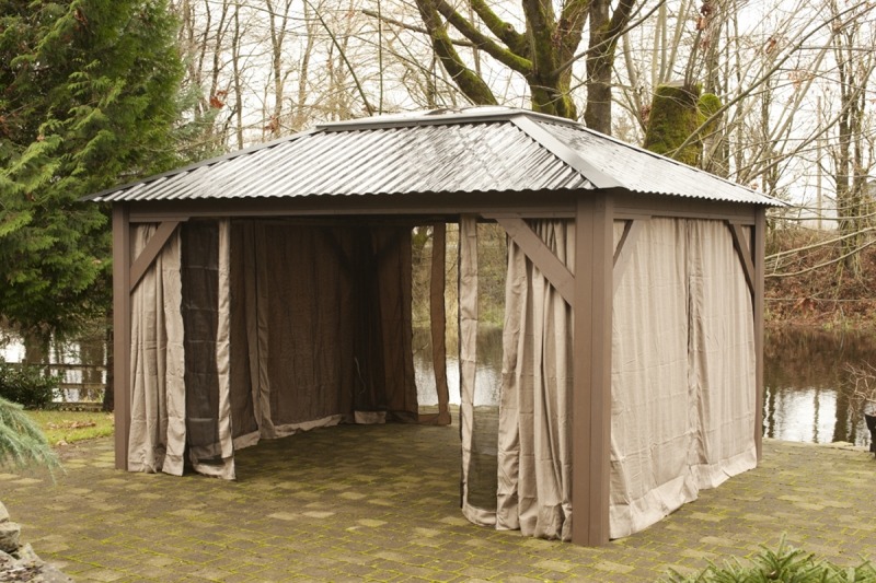 The side view of an open air Arctic Spas Gazebo with an open insect screen , model Della